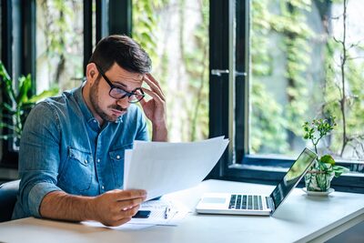 Businessman looking at reports, perplexed