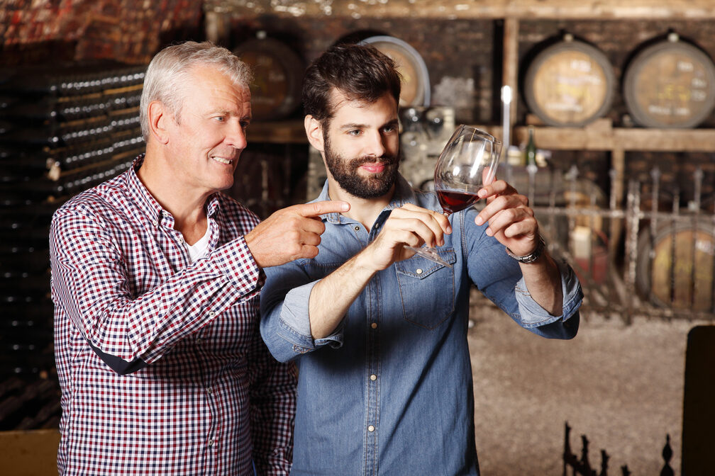 Father and son at winery examine quality of the latest batch