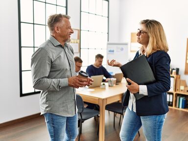 businessman and businesswoman confer in casual attire