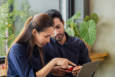 two young small business owners review computer report